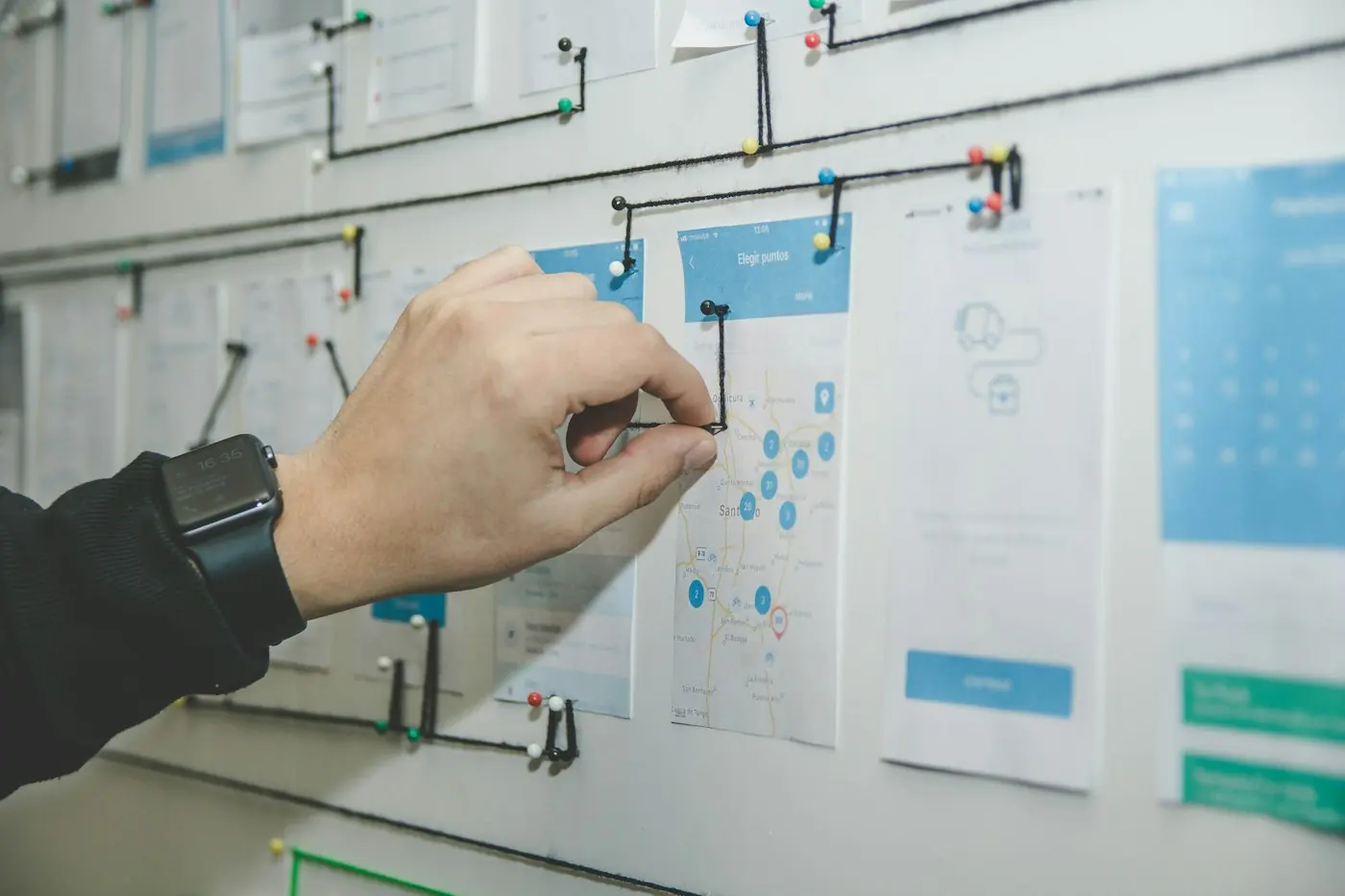 Tangan menyusun alur halaman website di papan kerja